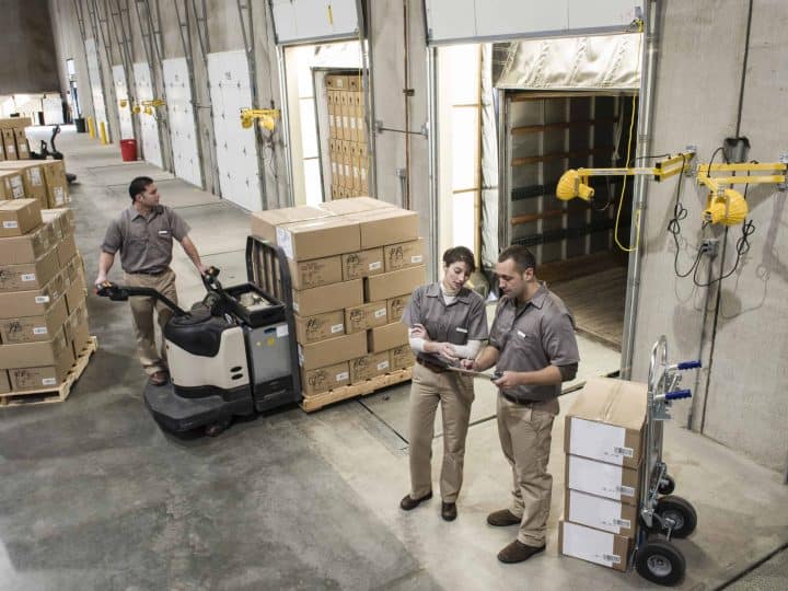 Manufacturing workers move boxes out of warehouse