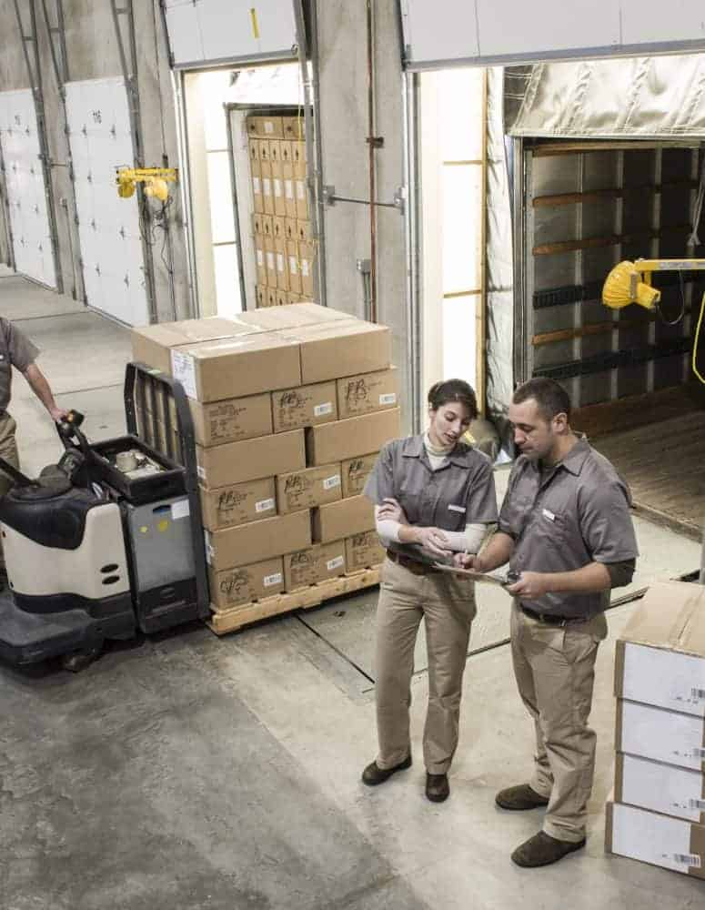 Manufacturing workers move boxes out of warehouse